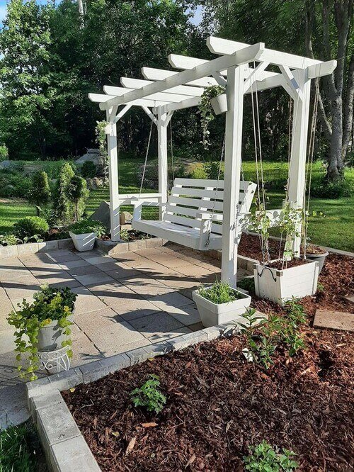 Transform your outdoor space with an inviting pergola adorned with a charming swing