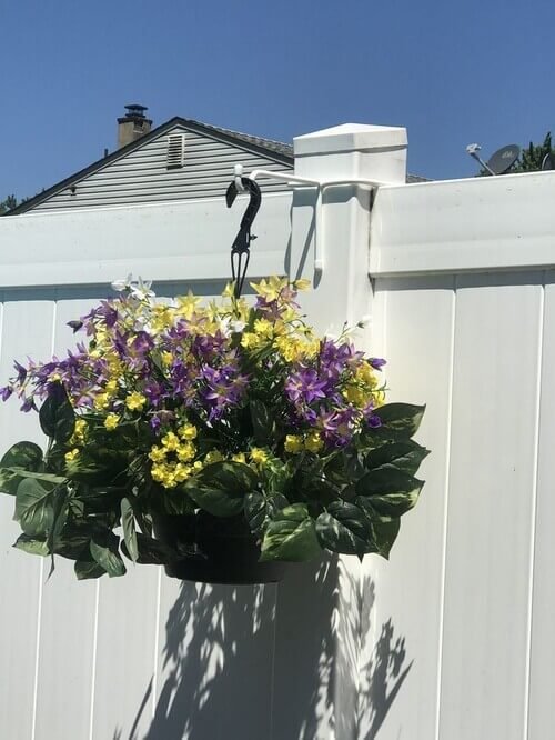 Maximize your vertical space by adorning your fence with hanging flower planters