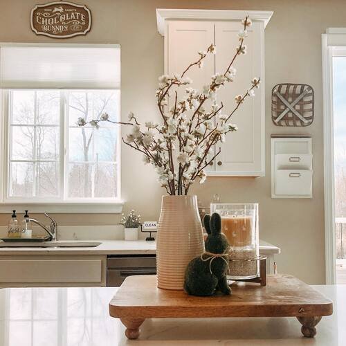 A spring-ready display of blossoms in ceramic jars, candles, and decorative rabbits
